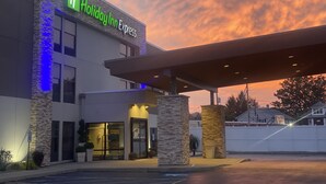 A Holiday Inn Express building with a stone facade and a covered entrance. - Holiday Inn Express Olean by IHG (Olean)