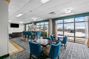 A conference room with a large table, chairs, a sofa, and a TV screen. - Quality Inn Cleveland, MS (Cleveland)