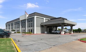 A building with a covered parking area and a flagpole. - Quality Inn Cleveland, MS (Cleveland)