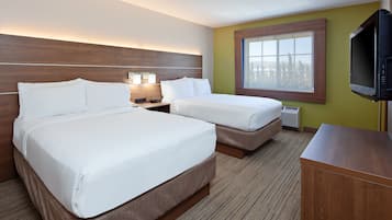 Habitación de hotel con dos camas, televisión, ventana y cabecero de madera.