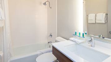 Een bad/douchecombinatie, een haardroger, handdoeken