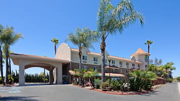 Stroll through the central courtyard surrounded by lush palm trees and a covered walkway.