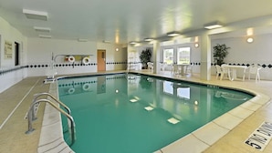 An indoor swimming pool with a tiled floor, a pool ladder, and a seating area with tables and chairs. - Hampton Inn Sturgis-Lagrange Area (Sturgis)