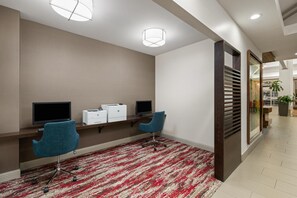A modern office space with two desks, chairs, and a red patterned carpet. - Hilton Garden Inn Portland Airport (Portland)