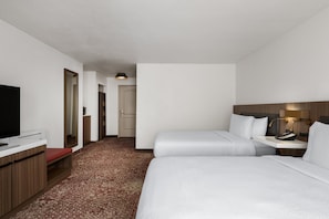 A hotel room with a bed, bedside table, lamp, and a television on a desk. - Hilton Garden Inn Portland Airport (Portland)