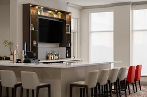 Una cucina moderna con un angolo bar, sgabelli da bar e un'ampia finestra.