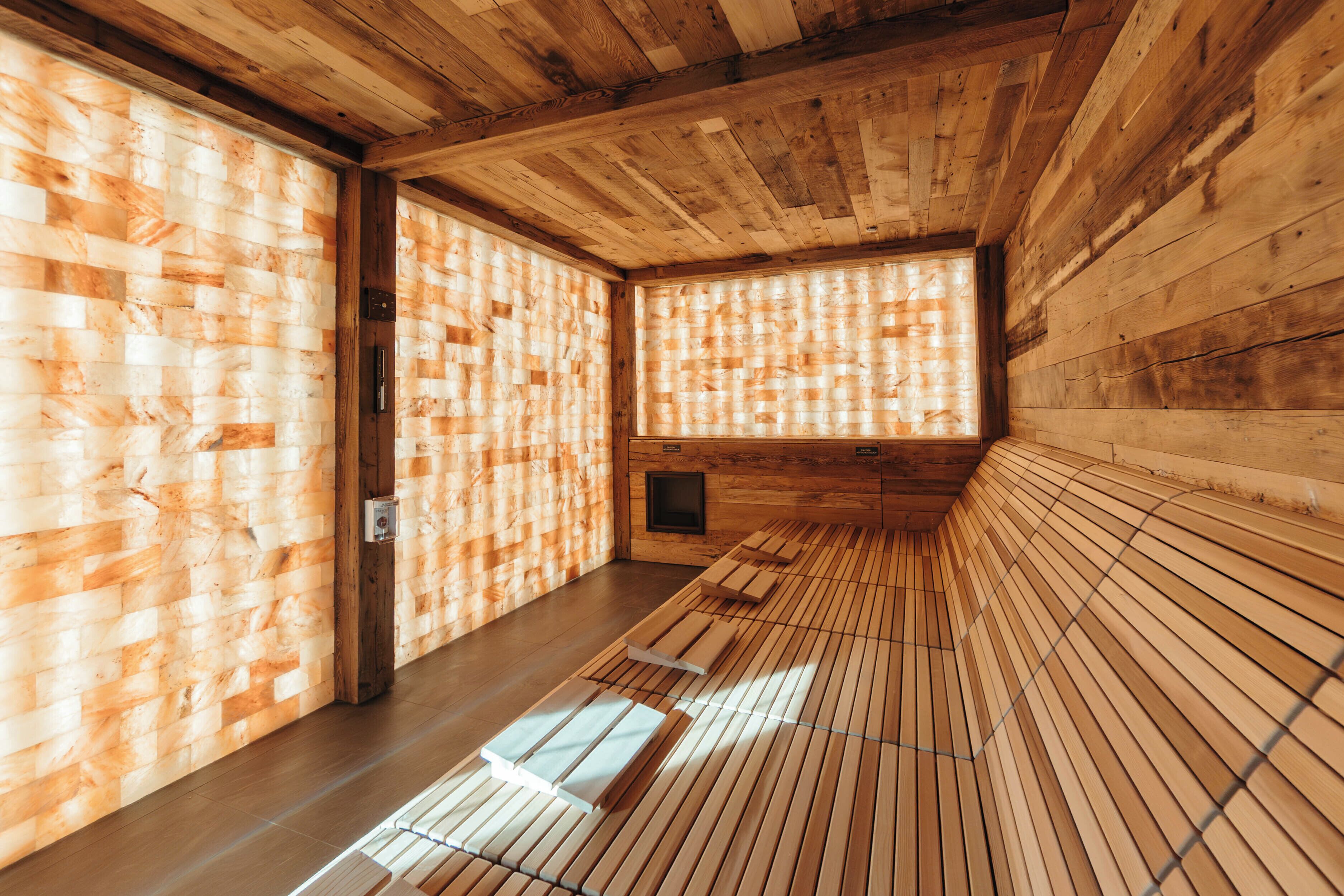 A wooden interior with slatted walls and a bench along the wall.