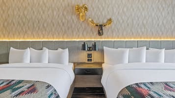 Una habitación de hotel con dos camas, un cabecero con panel iluminado y un adorno en la pared.