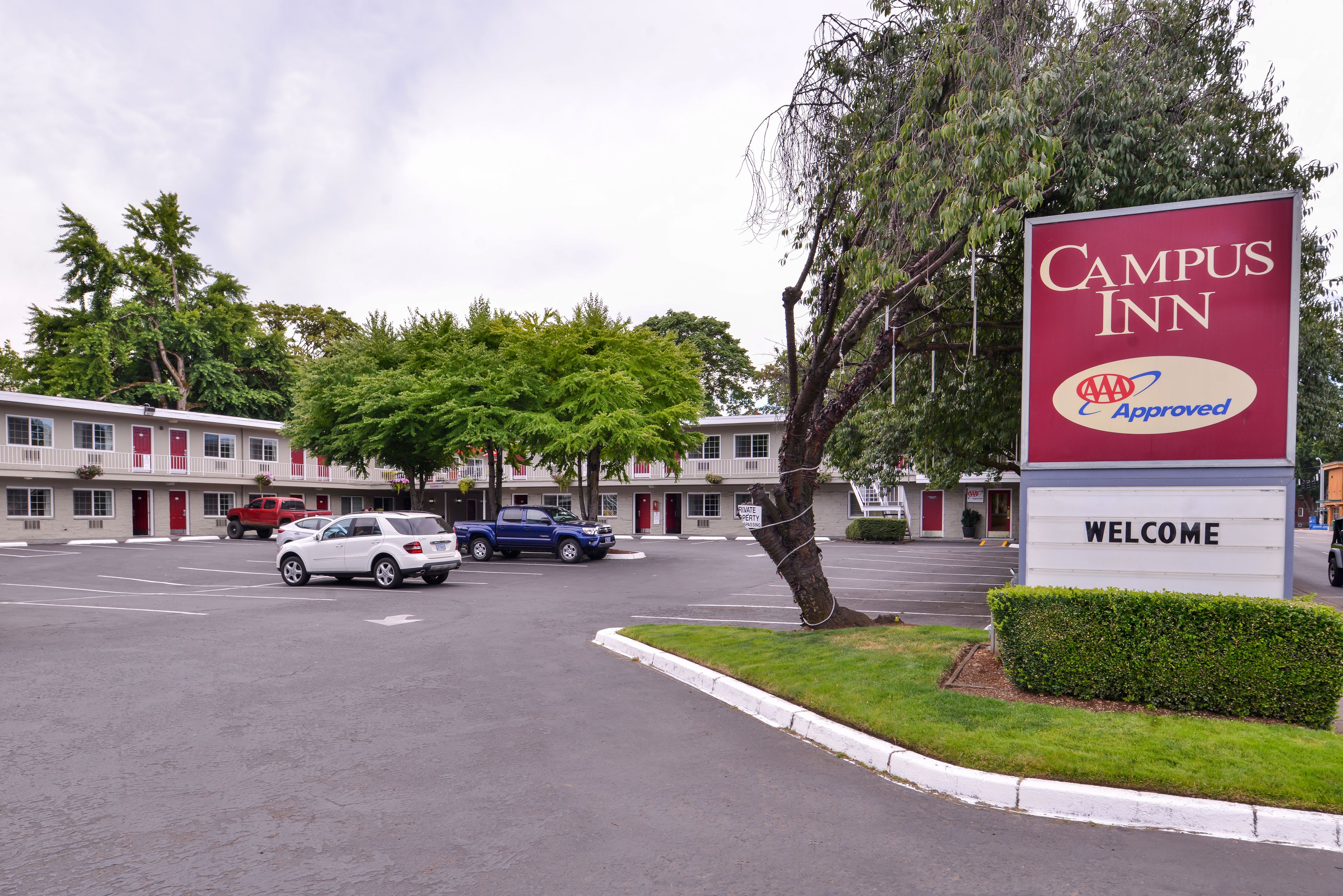A Campus Inn sign with a welcoming message, a parking lot, and a row of motel-style buildings.