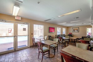 Un vestíbulo de hotel con varias zonas de estar, un letrero de salida y una señal que indica acceso a Wi-Fi gratuito.