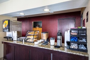 A breakfast bar with a coffee machine, a fruit display, and a beverage dispenser. - Red Roof Inn San Marcos (San Marcos)