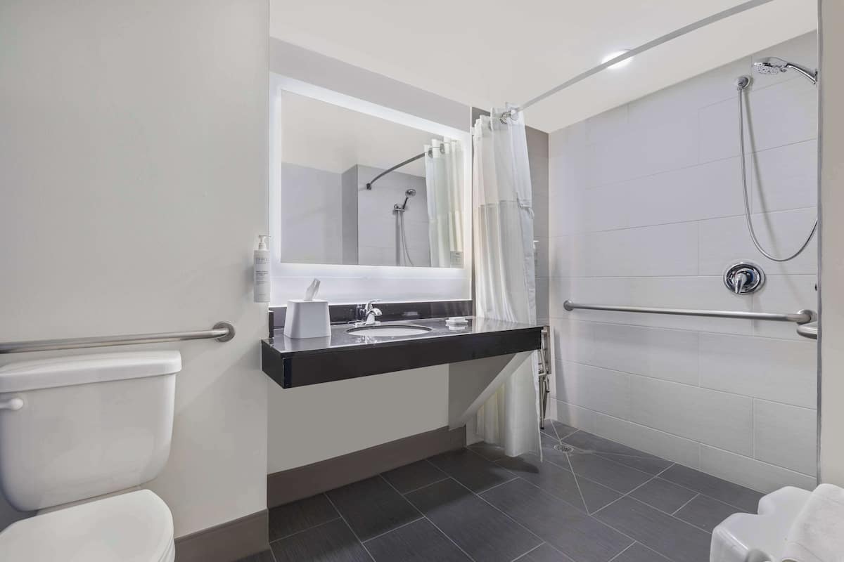 A modern bathroom with a toilet, sink, and shower area.