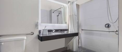Une salle de bain moderne équipée de toilettes, d’un lavabo et d’une zone douche.