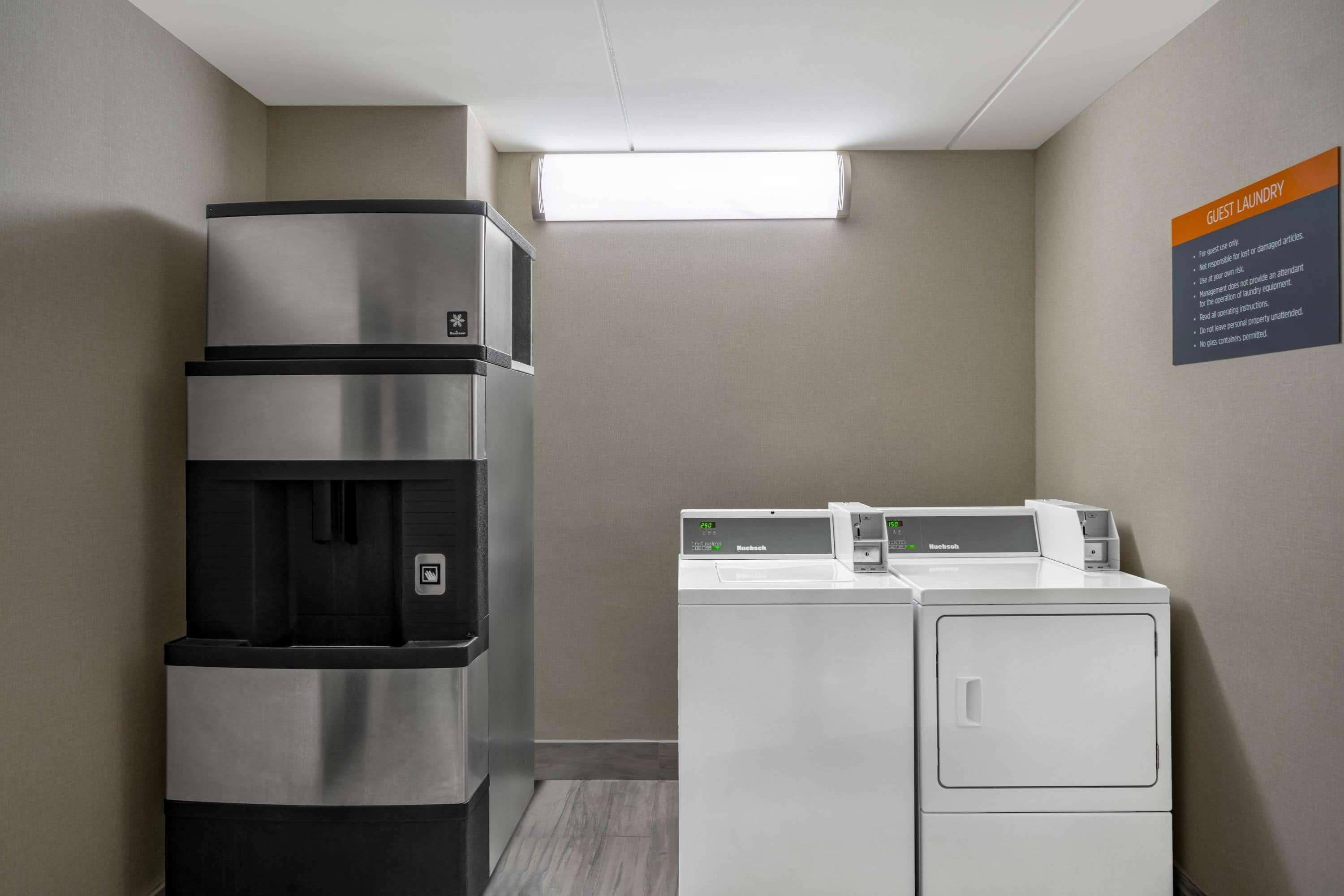 Un espace buanderie équipé d’un réfrigérateur, d’une machine à laver et d’un sèche-linge.