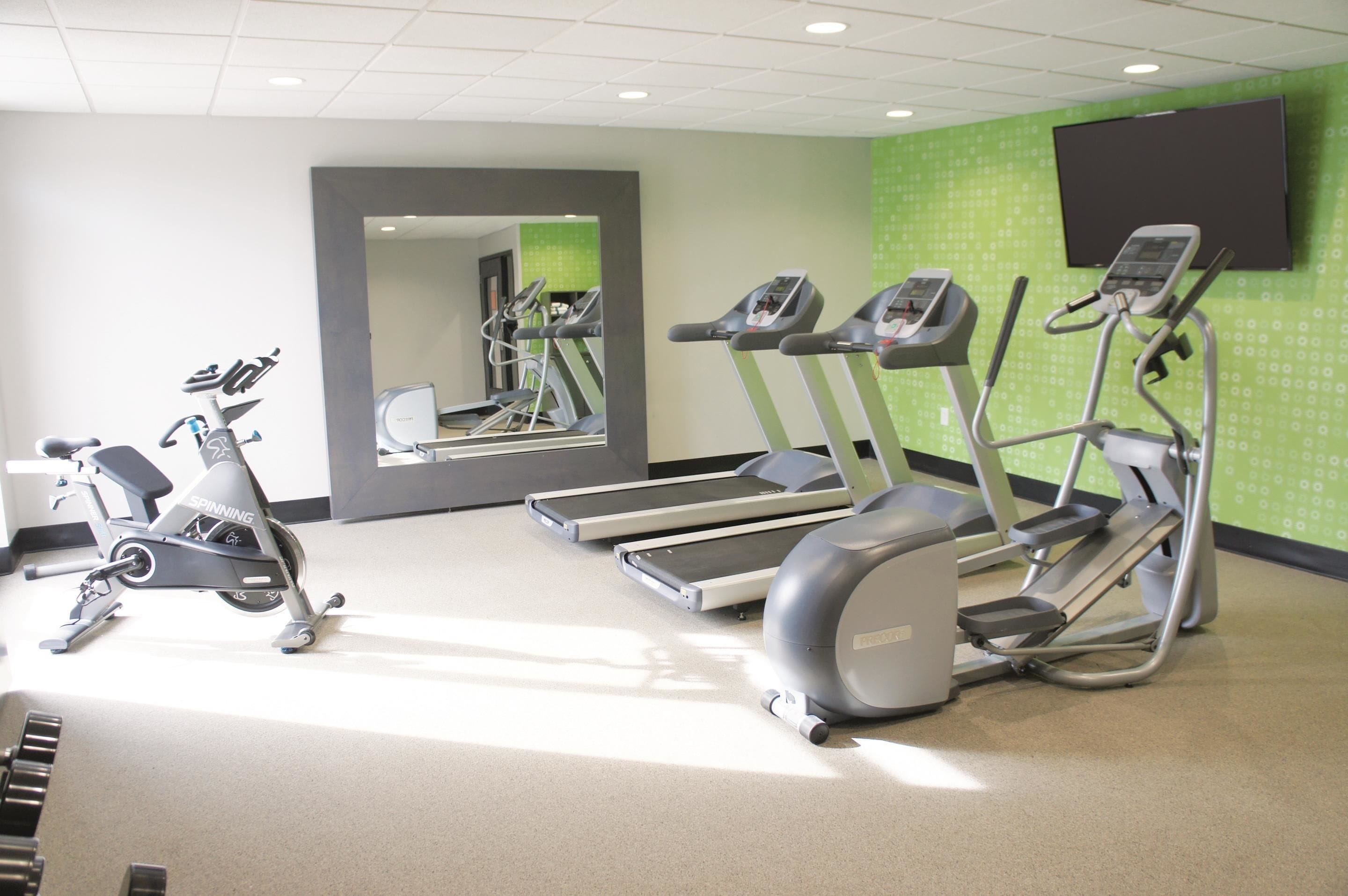 Una palestra con tapis roulant, ellittiche e cyclette.