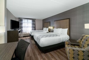 Habitación de hotel con dos camas, televisión, escritorio y silla.