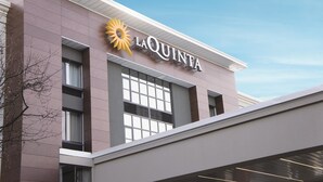 A modern building with the sign "LA QUINTA" and a sun logo. - La Quinta Inn & Suites by Wyndham Raleigh Downtown North (Raleigh)