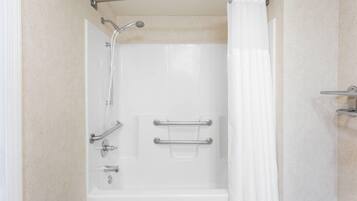 A walk-in shower with a glass door, a handheld showerhead, and a grab bar.