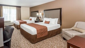 A hotel room with two beds, a desk, a chair, and a sofa. - Wingate by Wyndham - Joliet (Joliet)