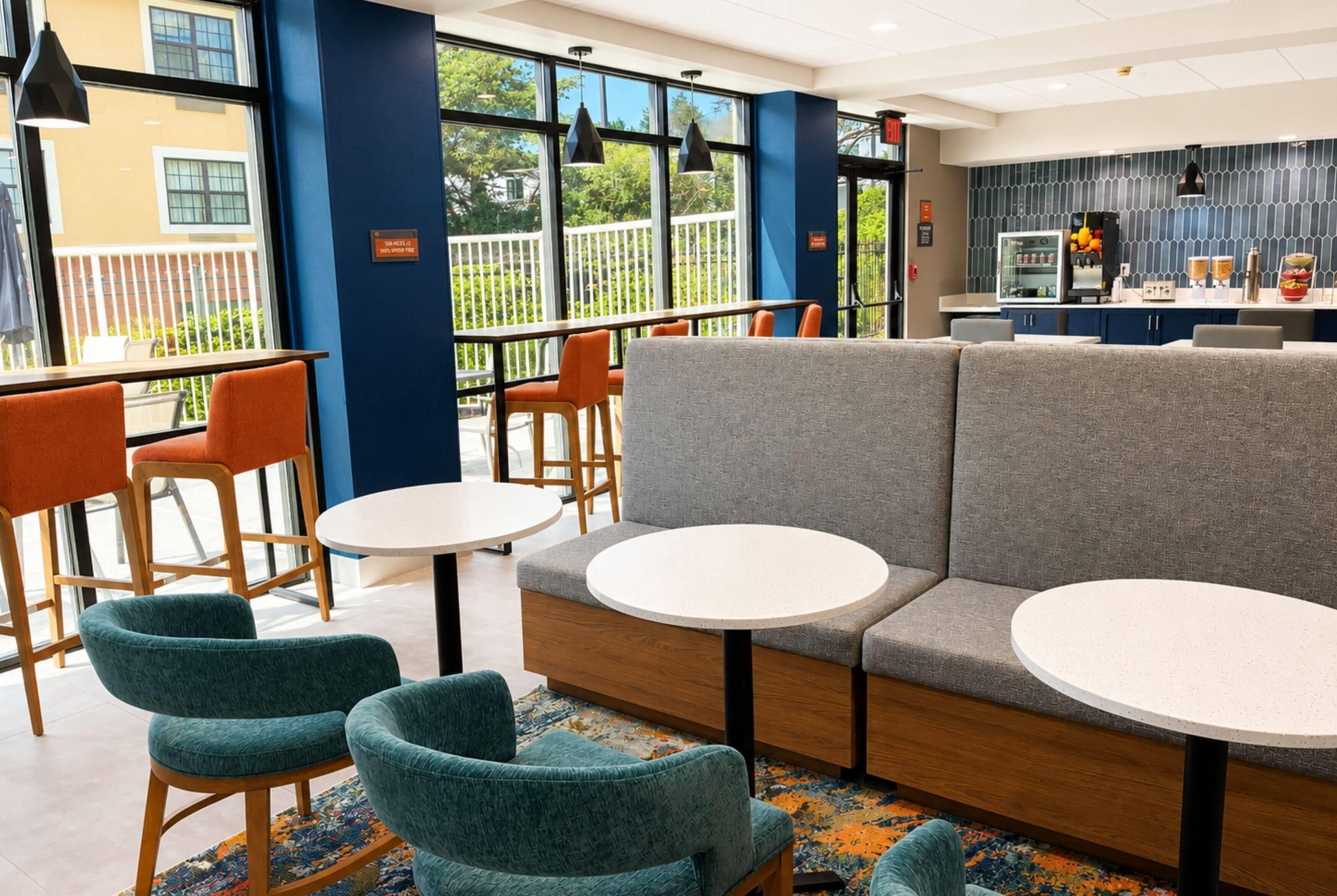Un interior moderno con arreglos de asientos, una zona de cocina y ventanas amplias.