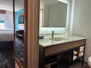 A modern bathroom with a large mirror, a sink, and a toilet. - La Quinta Inn & Suites by Wyndham Duluth/Atlanta (Duluth)
