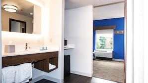 A modern bathroom with a wooden vanity, a mirror, a sink, and a small refrigerator. - Holiday Inn Express & Suites Nashville - Brentwood I-65 by IHG (Brentwood)