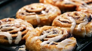 A tray of freshly baked cinnamon rolls with icing. - Holiday Inn Express & Suites Nashville - Brentwood I-65 by IHG (Brentwood)