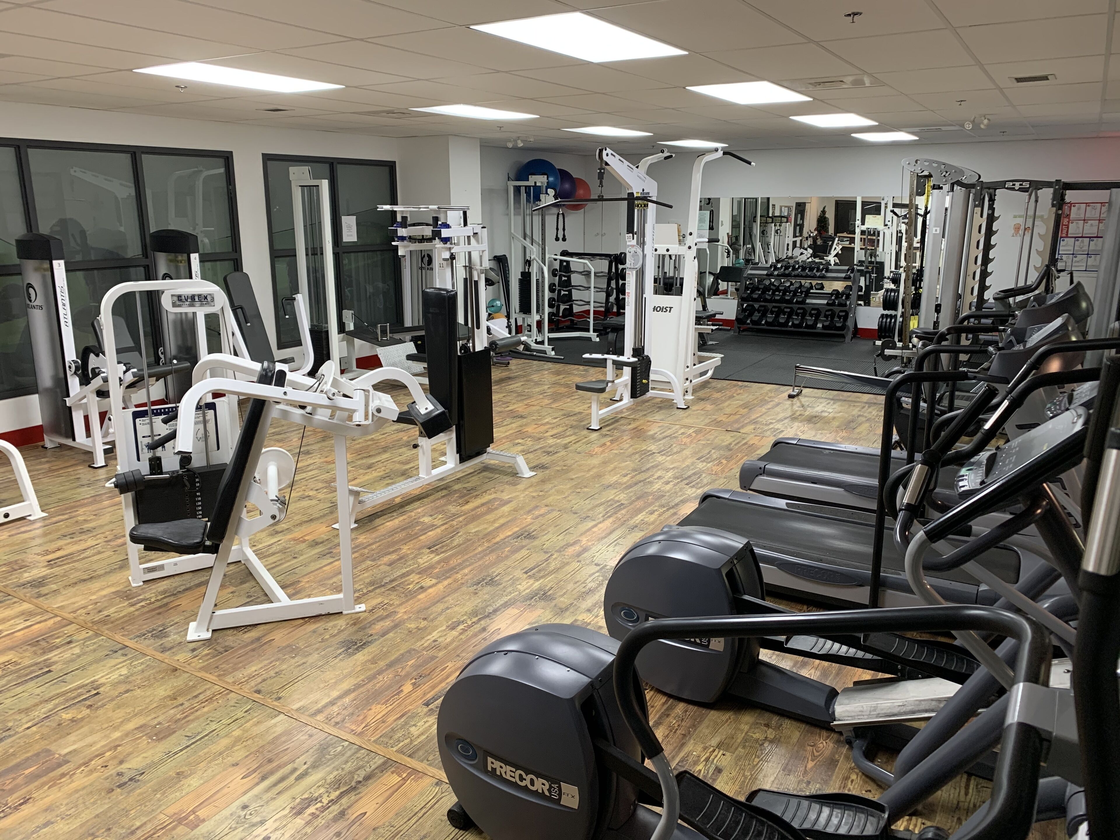 A gym with various exercise machines, treadmills, and weightlifting equipment.