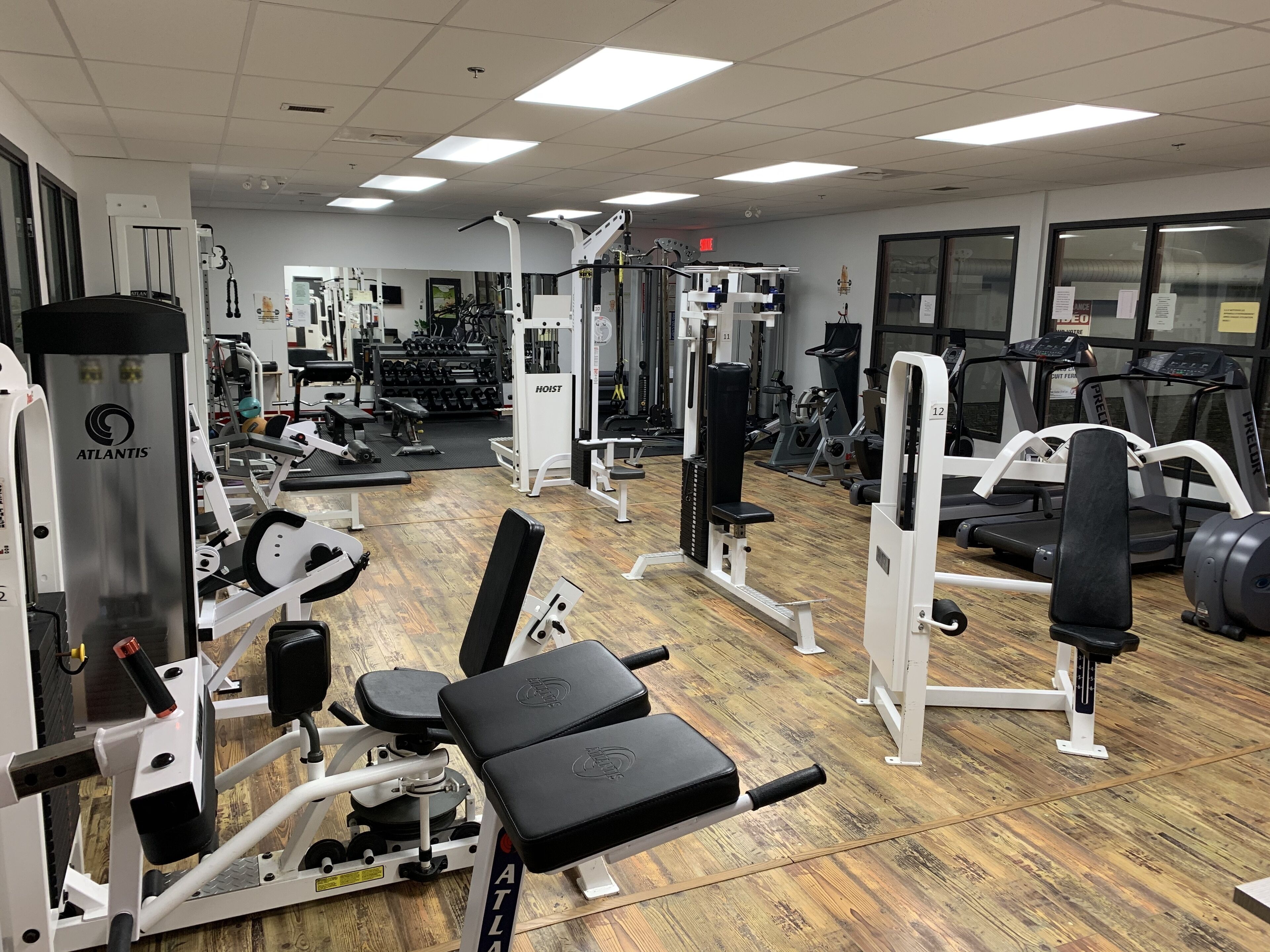 A gym with various exercise equipment, including weight machines, treadmills, and free weights.