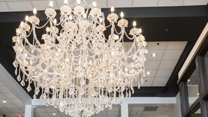 A spacious lobby with a grand chandelier, a staircase, and a visible gym area. - Hôtel Énergie Shawinigan (Shawinigan)
