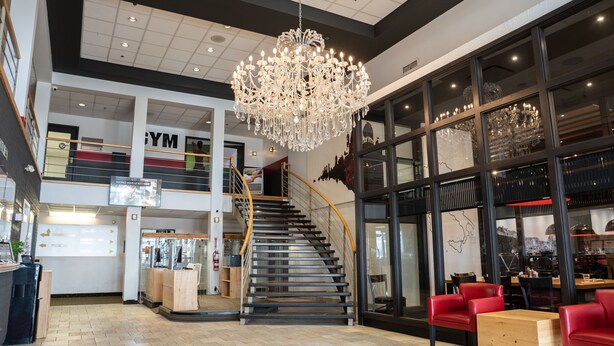 A spacious lobby with a grand chandelier, a staircase, and seating areas. - Hôtel Énergie Shawinigan (Shawinigan)