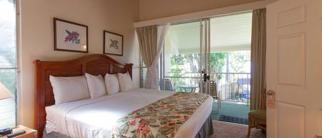 A bedroom with a bed, a ceiling fan, a window, and a door.