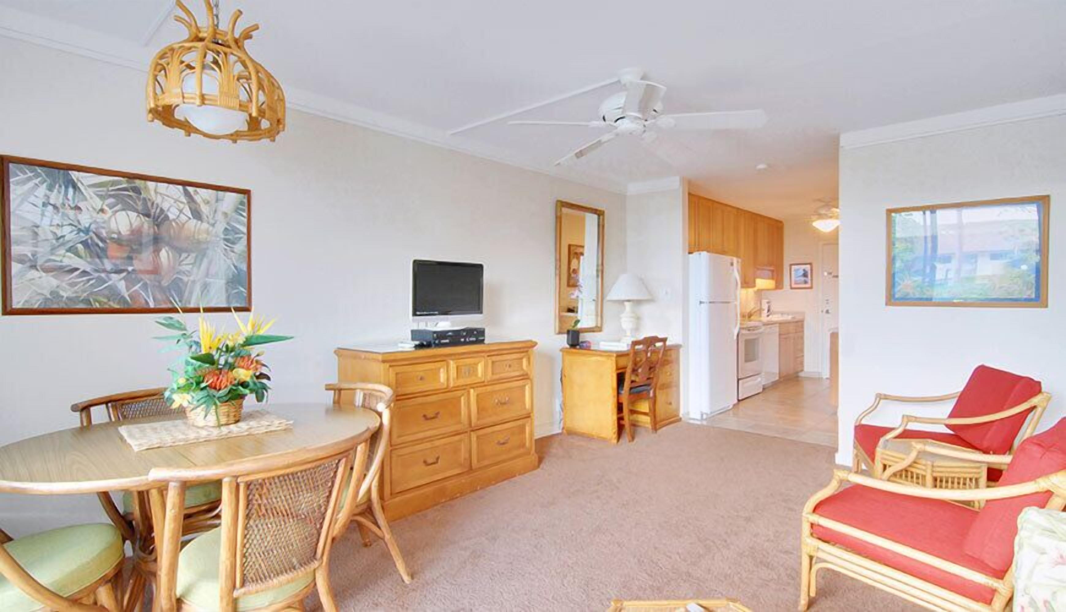 Ein geräumiges Wohnzimmer mit Essbereich, einer Küche und einem Schlafzimmer, das durch eine offene Tür sichtbar ist.