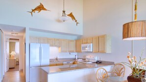 Una cocina moderna con electrodomésticos blancos, armarios de madera y una isla central.