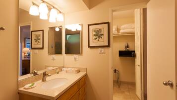 A bathroom with a sink, mirror, and towel rack.