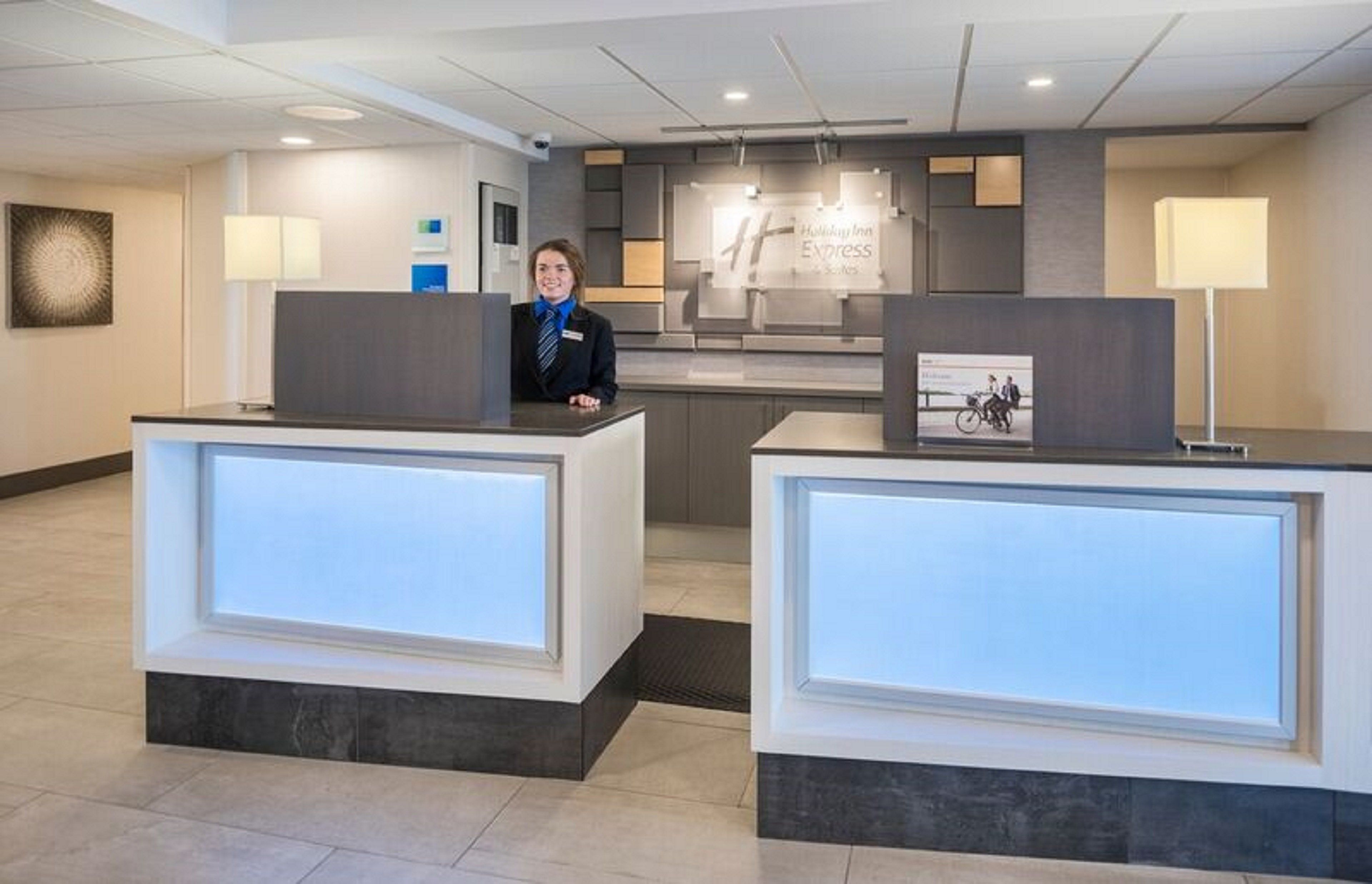 A reception desk with a digital display, a framed picture, and a sign for the Express Suites.