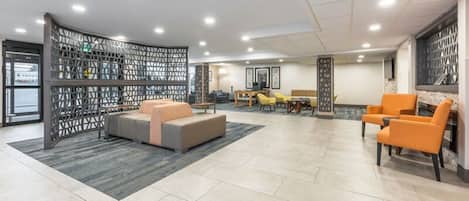 A spacious lobby with a seating area, a dining table, and a decorative partition.