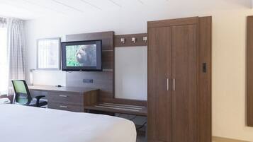 A hotel room with a bed, a desk, a television, and a wardrobe.