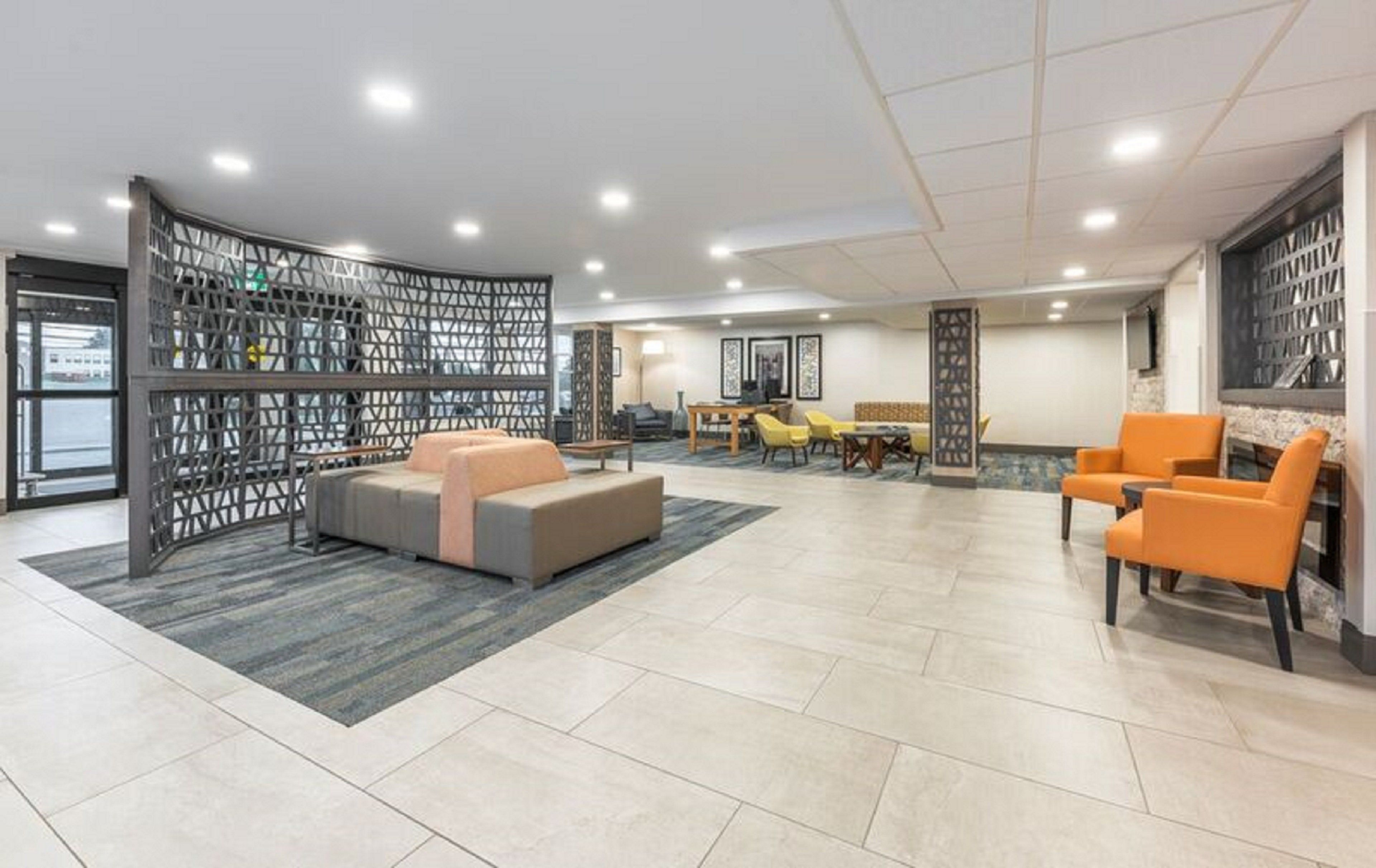 A spacious lobby with a seating area, a dining table, and a decorative partition.
