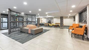 A spacious lobby with a seating area, a dining table, and a decorative partition.
