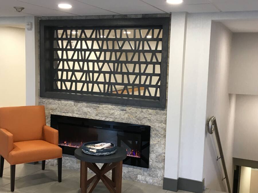 Una sala de estar moderna con chimenea, un sillón cómodo y una mesita con revistas.