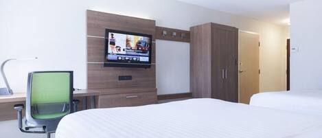 Una habitación de hotel con una cama, un escritorio con silla, un televisor montado en la pared y un armario.