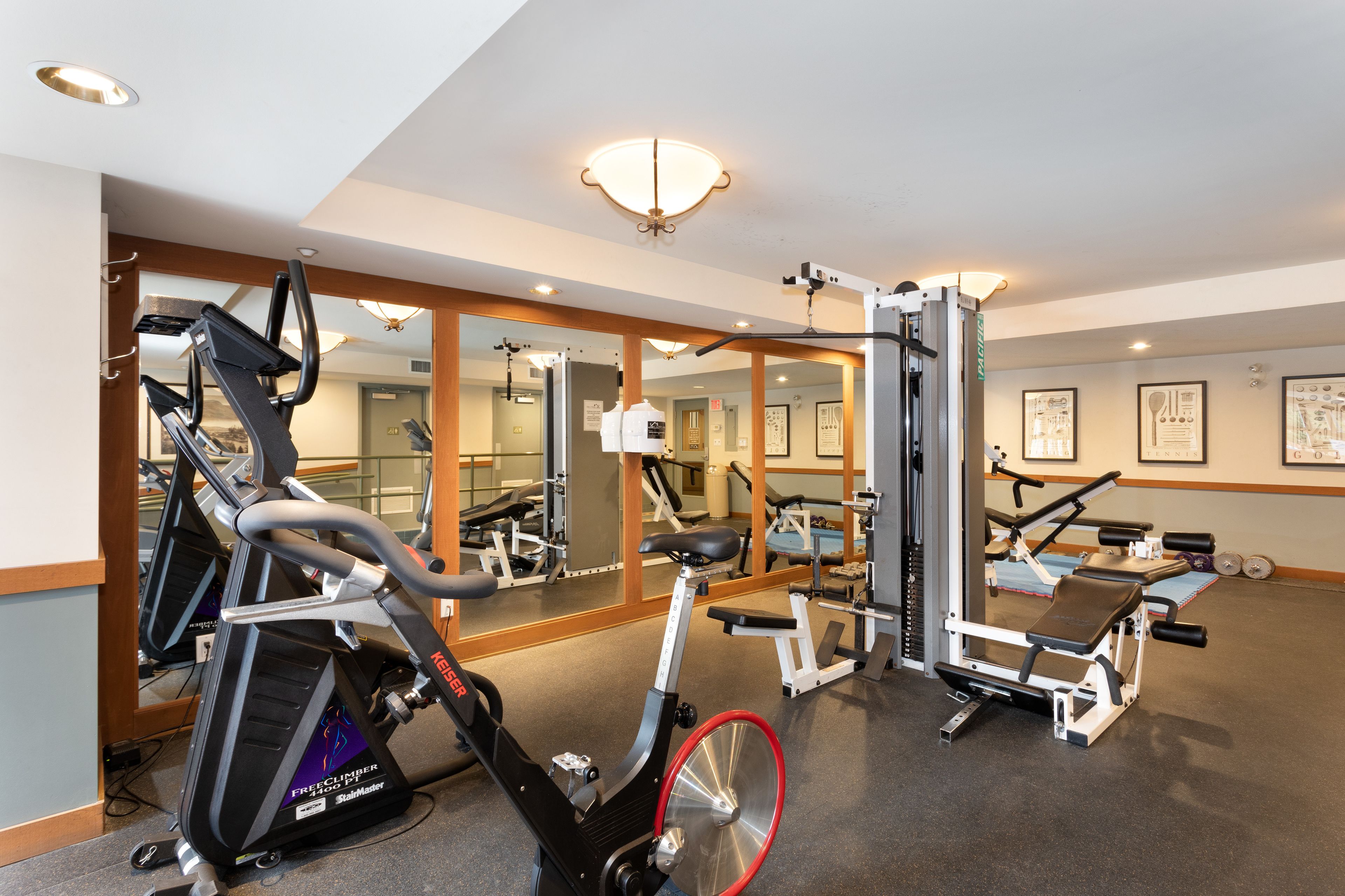A gym with cardio equipment, weight machines, and mirrors.