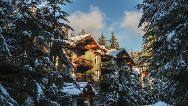 Un gran refugio con varios balcones y un paisaje cubierto de nieve.