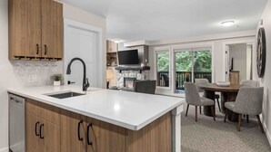 Una cocina moderna con una isla central, armarios de madera y televisor integrado.
