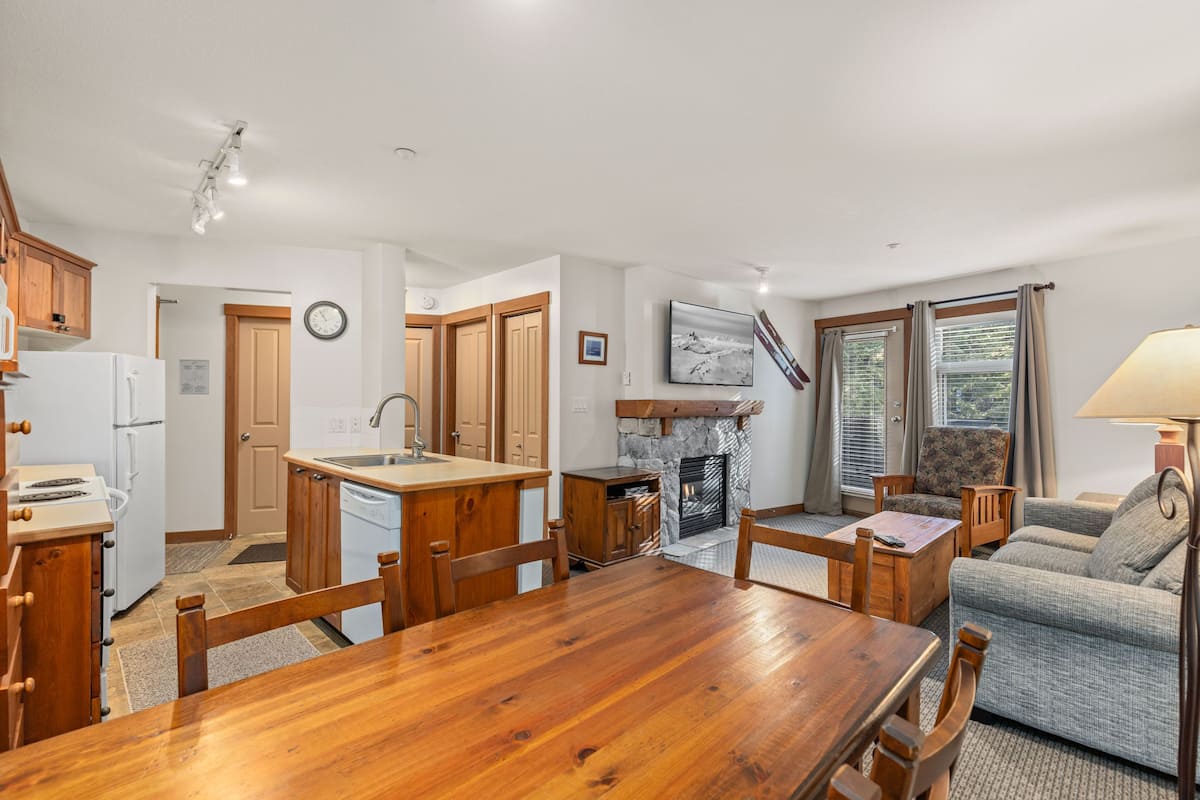 Una cocina amplia con armarios de madera, una mesa de comedor y una chimenea.