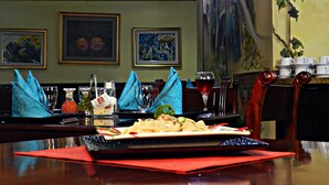 A dining table set with a plate of food, glasses, and napkins.