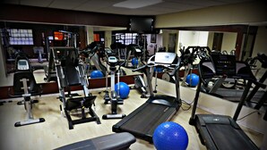 A gym with treadmills, elliptical machines, and free weights.