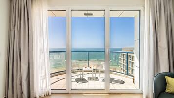 Ein Balkon mit Blick auf das Meer und ein Gebäude gegenüber.