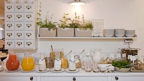 A breakfast buffet with various food and drink options, including juices, milk, and cereal. - Shalom Hotel & Relax - an Atlas Boutique Hotel (Tel Aviv)